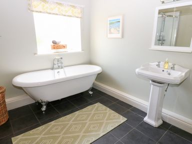 A bathroom with a bathtub and sink at Shepherds Burn Cottage in Bellingham