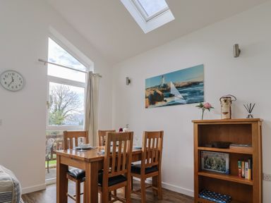 A dining room with a table and chairs at Keepers Cottage Sidmouth