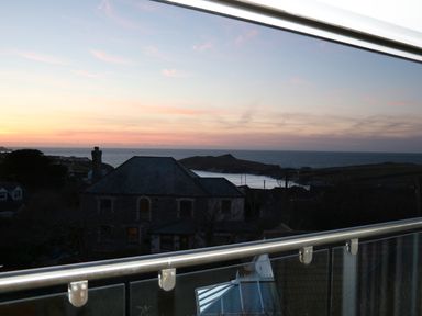 A coastal view with houses and the ocean at sunset seen from a balcony at Sunset View in Porth