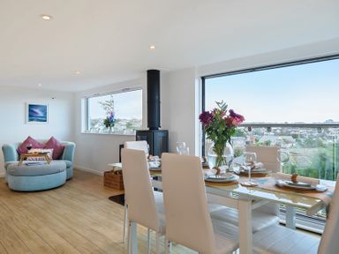 A living room with a dining table and armchair at Sunset View in Porth