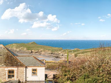 A view of the ocean and cliffs near a house at Sunset View in Porth
