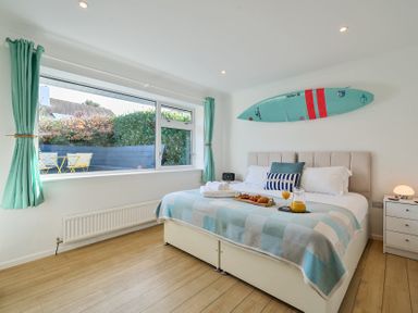 A bedroom with a bed and windows at Sunset View in Porth