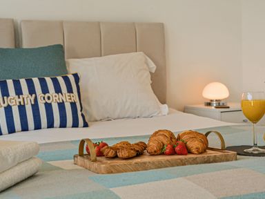 A bedroom with a bed and breakfast items at Sunset View in Porth