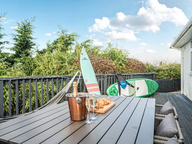 An outdoor dining area with surfboards on display at Sunset View in Porth
