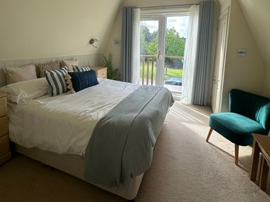 A bedroom with a bed and sliding door at Lodge 22, Bodmin Holiday Park, Cornwall Lanivet