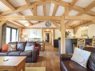 A living room with sofa and dining area at Lady Bagots Cabin in Ruthin