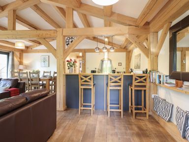 A living room with wooden beams and seating at Lady Bagots Cabin in Ruthin