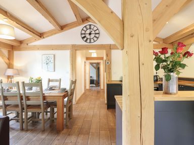 A dining room with a wooden table and chairs at Lady Bagots Cabin in Ruthin