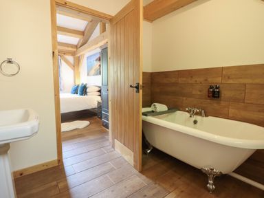 A bathroom with a bathtub and sink at Lady Bagots Cabin in Ruthin