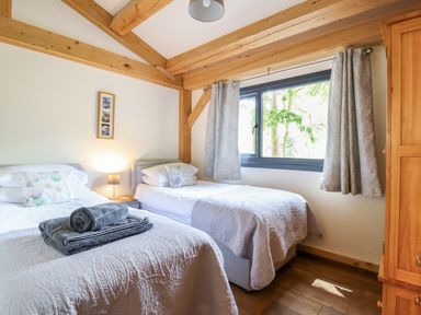 A bedroom with two beds and a window at Lady Bagots Cabin in Ruthin