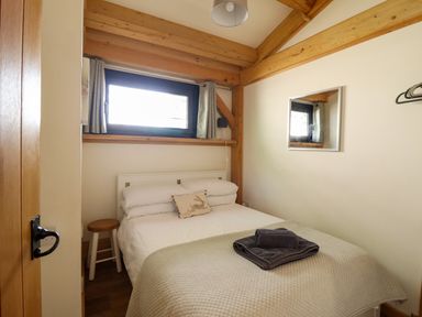 A bedroom with a bed and a window at Lady Bagots Cabin Ruthin