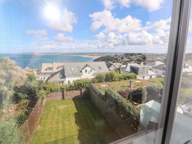 A garden with grass and shrubs overlooking houses and the sea at Seafield in Carbis Bay near St Ives