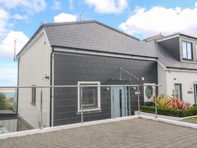 Exterior of a two story house with a tiled roof metal railing and paved driveway at Seafield in Carbis Bay near St Ives