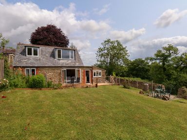A house with gardens and trees at Mallows Byre in Yetminster