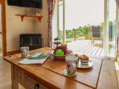 A living room with a table and fruit at Mallows Byre in Yetminster