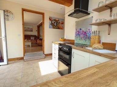 A kitchen with an oven and cutting board at Mallows Byre in Yetminster