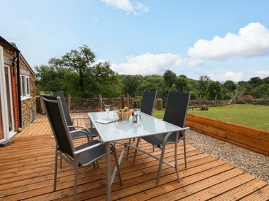 An outdoor area with a table and chairs at Mallows Byre in Yetminster
