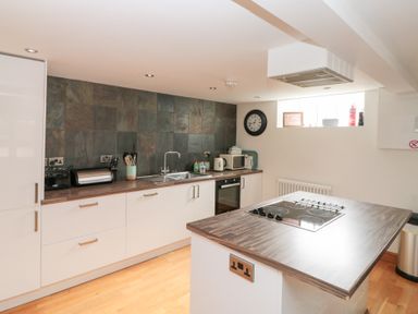 A kitchen with cabinets countertop a stove sink and small appliances at Old Chapel in Cloughton