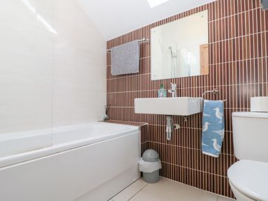 A bathroom with a bathtub sink mirror towel and toilet at Old Chapel in Cloughton