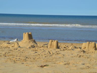 Sandcastles on a sandy beach with sea and sky in the background at 20 Siesta Mar in Mundesley