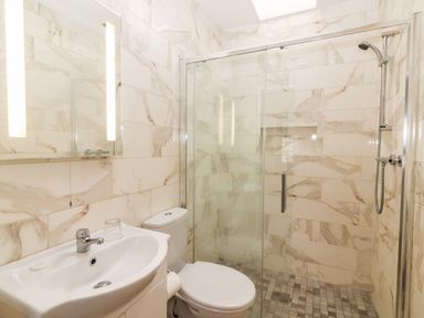 A bathroom with a sink toilet and a glass shower enclosure at Laharn Cottage in Killorglin County Kerry