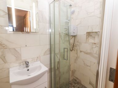 A bathroom with a sink a mirror and a glass door shower at Laharn Cottage in Killorglin County Kerry