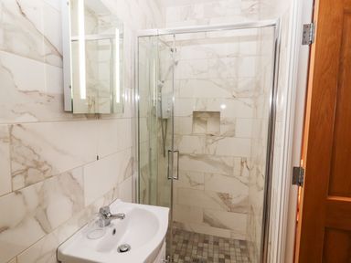 A bathroom with a sink and a glass-enclosed shower at Laharn Cottage in Killorglin County Kerry