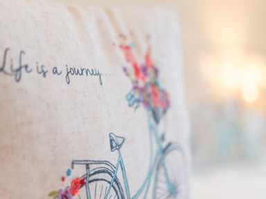A close up of a fabric with a bicycle and flowers and the text life is a journey