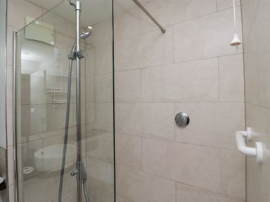 A shower area with a handheld showerhead and glass partition in a bathroom at 6 Mill Wharf in Berwick-upon-Tweed