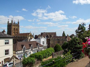 A townscape view with historic buildings and a church tower under a blue sky in Garden View in Malvern