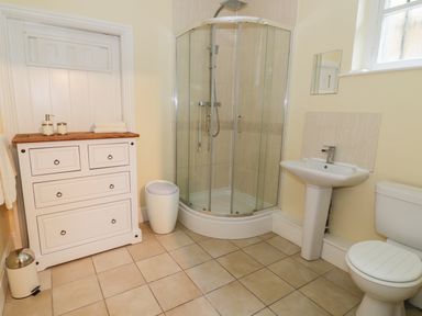 A bathroom with a shower enclosure a sink a toilet and a cabinet at Garden View in Malvern