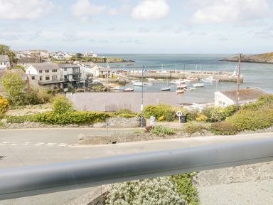 A view of a coastal village with houses boats in the harbor and the sea in the background at Harbour View in Cemaes Bay