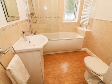 A bathroom with a sink cabinet a towel holder a bathtub a shower a toilet and a window at Coniston Number 9 in White Cross Bay