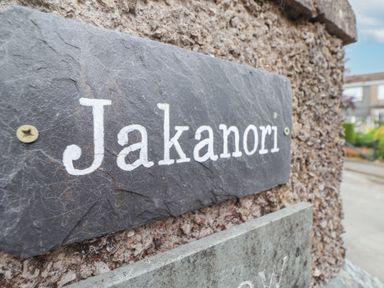 A slate stone nameplate with the word Jakanori mounted on a rough textured wall outside a residential area at Jakanori in Staveley