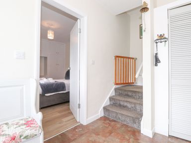A hallway with stairs and a baby gate next to a doorway leading to a bedroom at Jakanori in Staveley