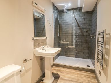 A bathroom with a pedestal sink toilet glass shower enclosure and towel rack at Lowdale Barns East in Sleights