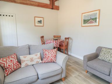 A living room with a sofa and dining area at The Cider Press, Motcombe