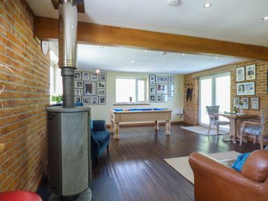 A recreational room with a pool table wooden floor and seating at Blue Oyster in Mullion near Lizard Point