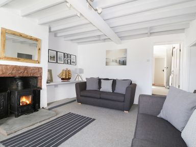 A living room with two gray sofas and a fireplace at Marsh Villa in Silloth
