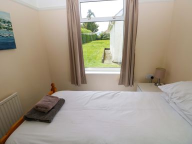 A bedroom with a bed and towels on it at White Thorns in Haverfordwest