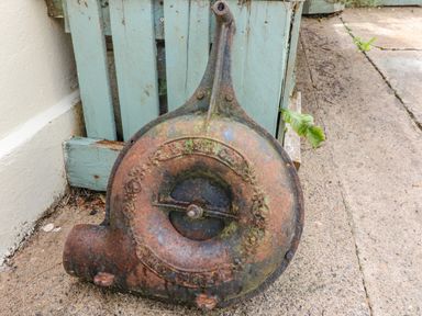 An old rusty metal object leaning against a wooden pallet on a concrete ground at Shandrum Brook in Charleville