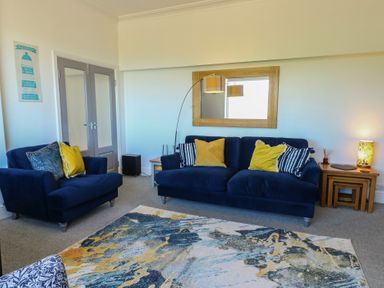 A living room with a sofa and armchair at Little Orme View in Llandudno