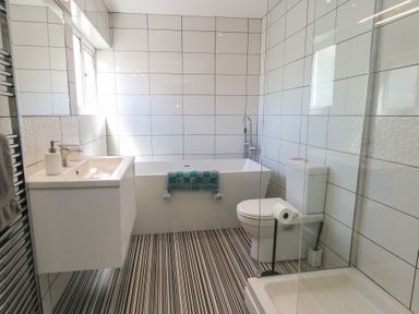A bathroom with a tub and shower at Little Orme View in Llandudno