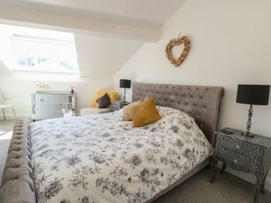 A bedroom with a bed and a side table at Little Orme View in Llandudno