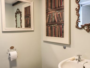 A bathroom with two mirrors a soap bar on a sink and a toilet paper holder at Beulah Cottage in Green Bottom near Littledean