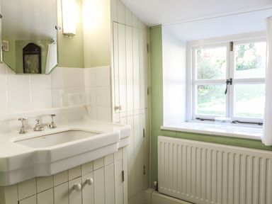 A bathroom with a sink cabinet mirror window and radiator at Beulah Cottage in Green Bottom near Littledean