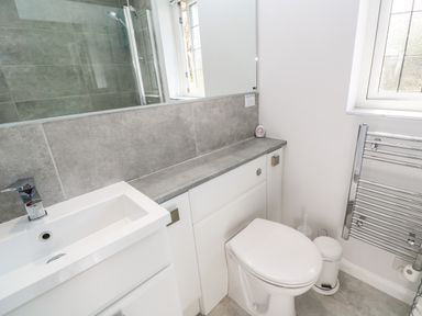 A bathroom with a toilet sink countertop and towel radiator at Rockpool in Harlyn Bay near St Merryn