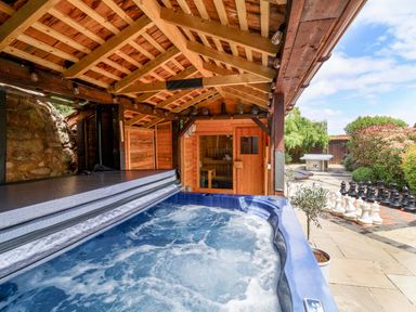An outdoor area with a hot tub and sauna at The Linhay in Washford near Watchet