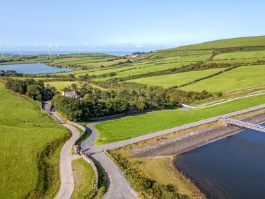 A scenic landscape with fields and water at Elm Lodge in Ulverston