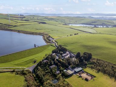 A landscape with a lake and fields at Elm Lodge in Ulverston